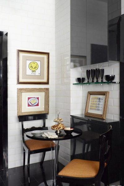 A small black and white kitchen with a table and chairs.