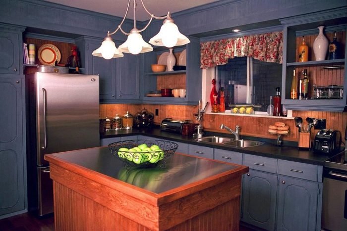 Small kitchen with blue cabinets and a wooden island.