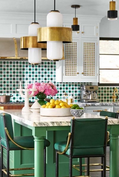 A small kitchen with green tile and gold accents.
