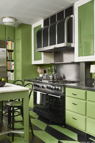 A small green kitchen with a black and white checkered floor.
