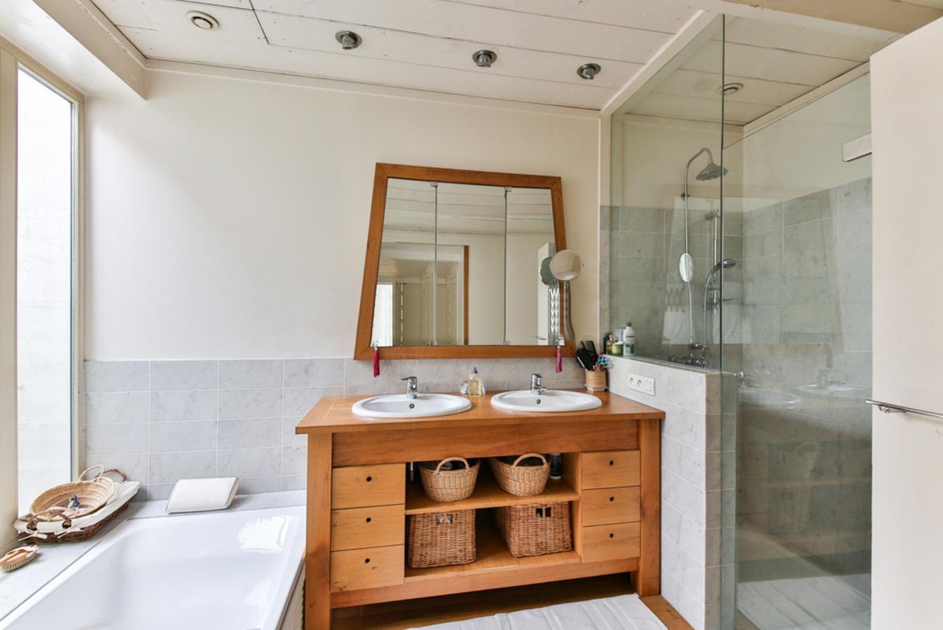 An up-to-date bathroom featuring a glass shower and wooden vanity.