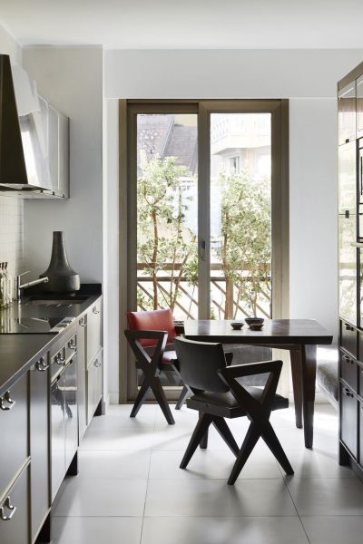 A small black and white kitchen with a table and chairs.