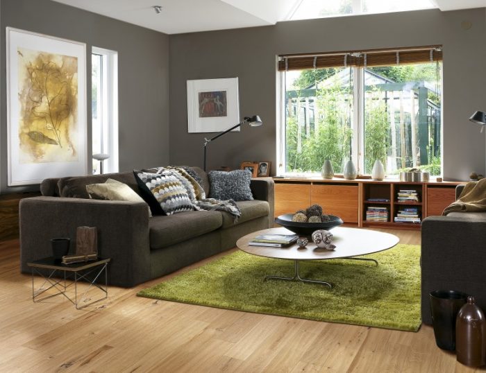 An impressive living room with grey walls and a green rug.