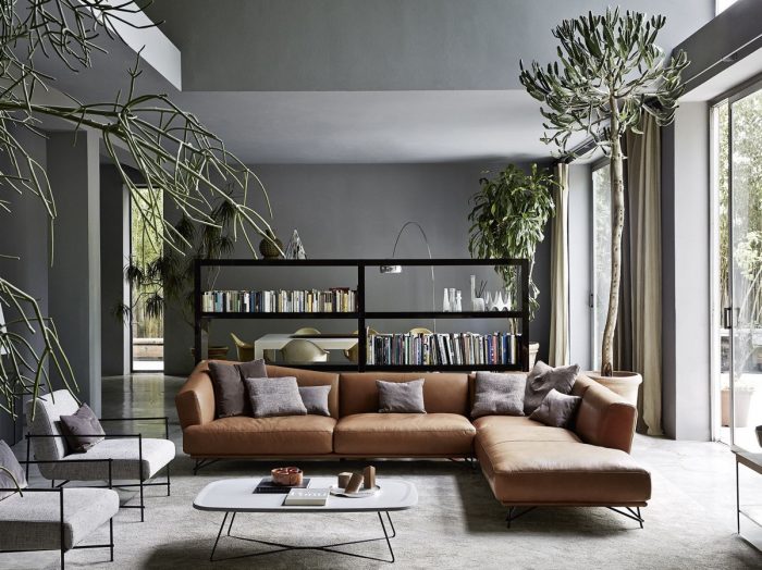 An impressive living room with a sectional sofa and bookshelf.