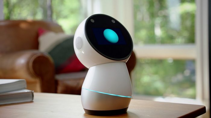A smart robot sitting on a table next to a window in a smart home.