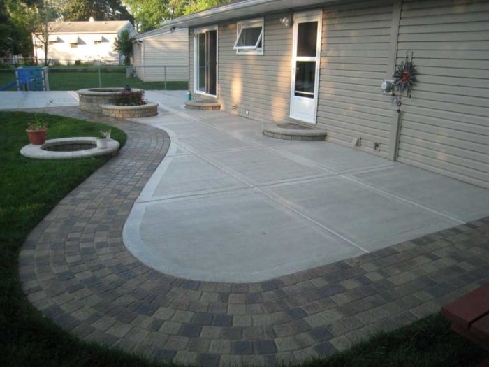 A fantastic backyard with a patio and fire pit using stamped concrete.