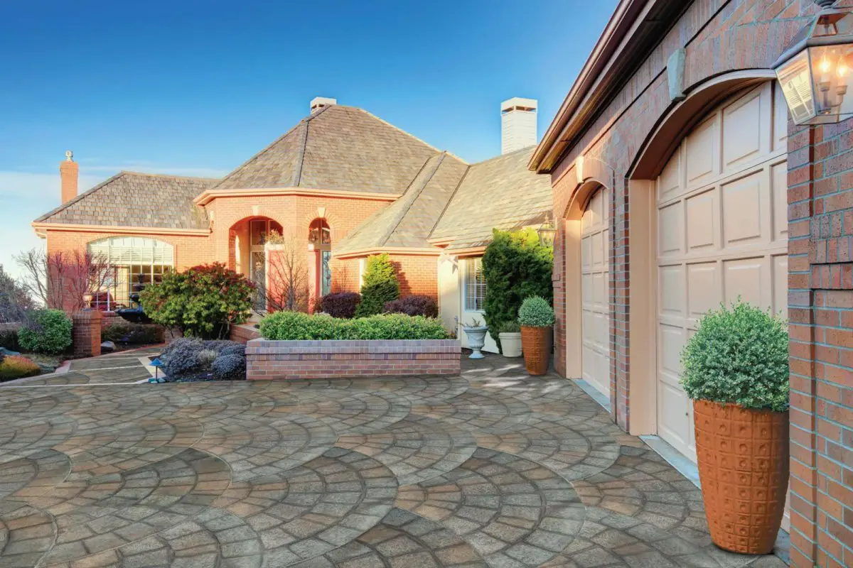 Elegant brick house with landscaped driveway.