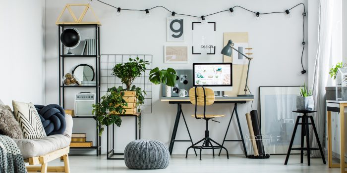 Home office with desk, chair, and plant.