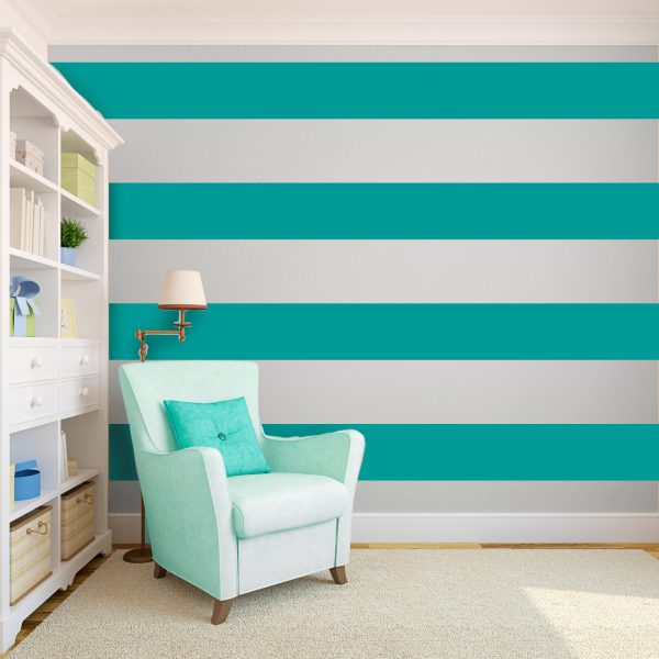 A room with a teal striped wall finished with wallpaper.