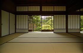 An empty Japanese room with bifold doors and a large window.