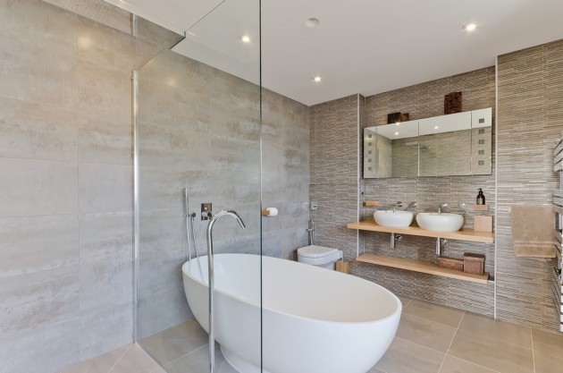 A modern bathroom with a glass shower enclosure that can increase the value of your house.