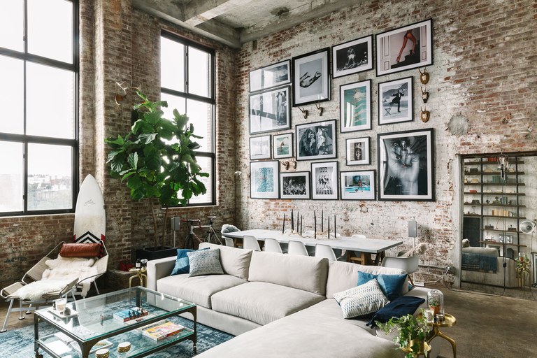 A brick-walled living room with a couch showcasing interior design.