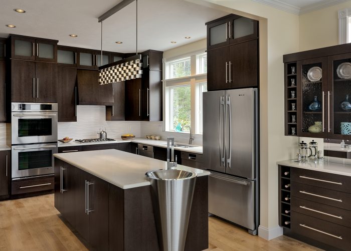 A kitchen remodeling project with dark wood cabinets and stainless steel appliances.