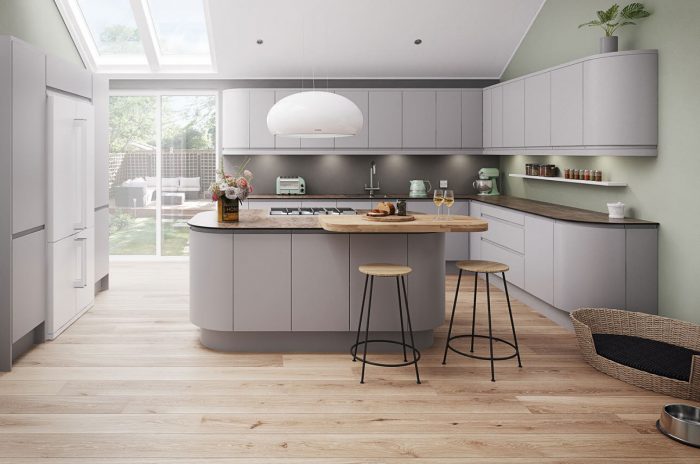 A modern kitchen with grey cabinets and a wooden floor undergoing kitchen remodeling.