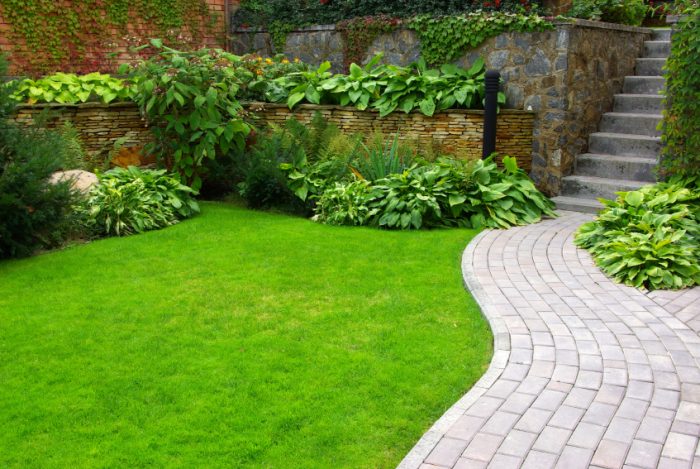 A garden with a brick walkway and flowers can increase the value of a house.