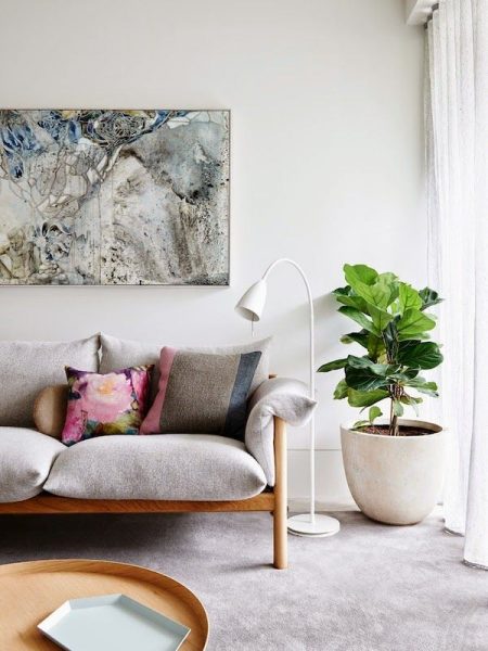 Keywords: living room modification, grey couch arrangement

Modified Description: Modifying a living room with a grey couch by incorporating a potted plant.