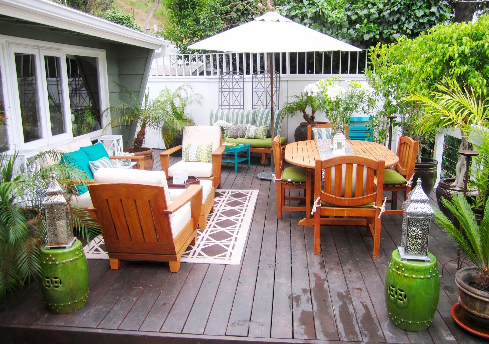 A wooden deck with outdoor furniture and potted plants featuring outdoor features.