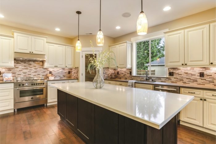 A kitchen with white cabinets and a center island featuring 2019 kitchen trends.
