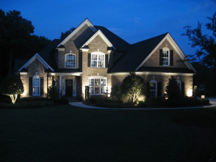 A home is lit up at night with outdoor lighting to enhance home security.