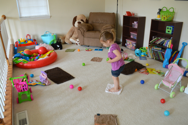 A young girl enjoying natural toys in a peaceful living room.