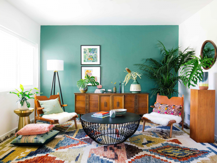 Spruce up living room with green walls and a colorful rug.