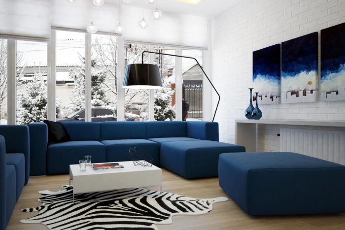 A living room with blue couches and zebra rug gets a spruce up.