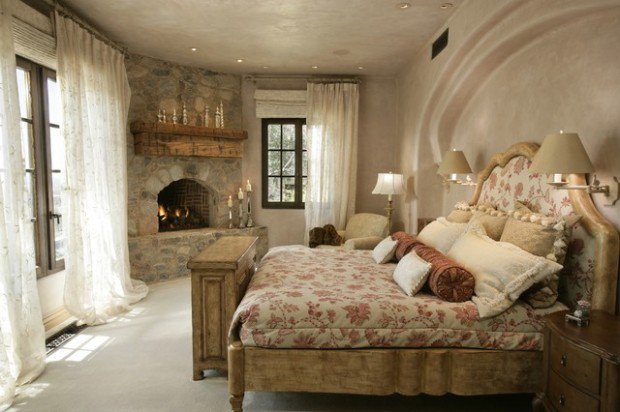 A lavish bedroom featuring an ornate bed and a cozy fireplace.