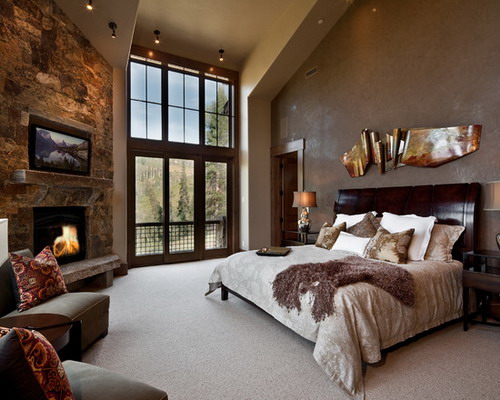 A cozy bedroom featuring stone walls and a fireplace.
