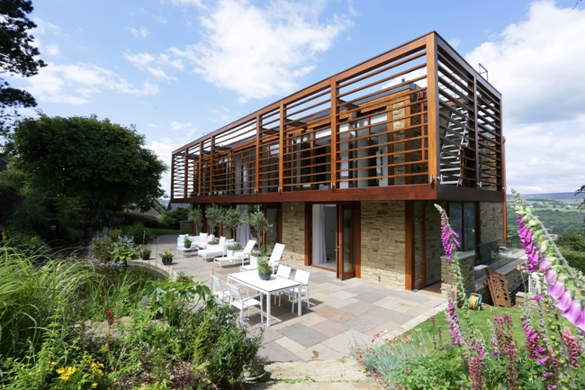 A tech-savvy home with wooden slats and a garden.
