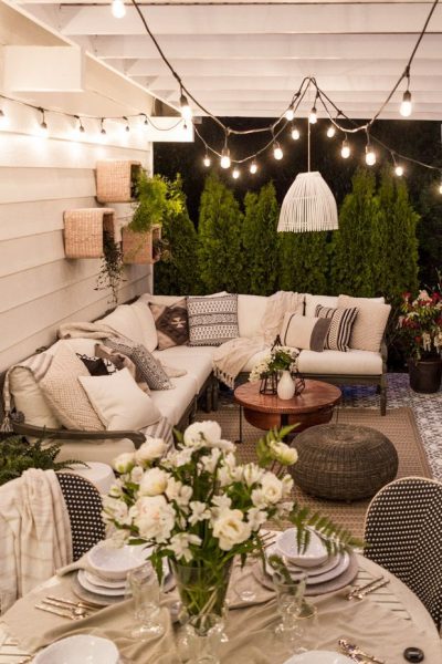 An outdoor dining area with white furniture and string lights, reflecting Home Decor Trends for Summer 2019.
