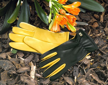 A pair of gloves for gardening laying on the ground.