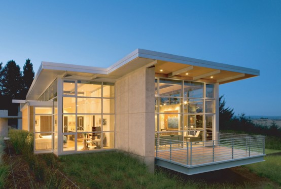 A tech savvy home with glass walls and a grassy yard.