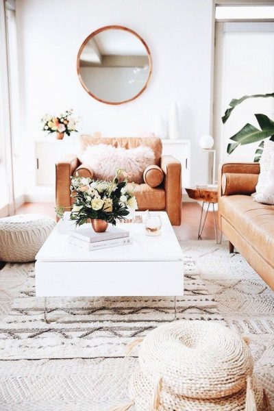 A white living room with brown leather furniture, following home decor trends for Summer 2019.