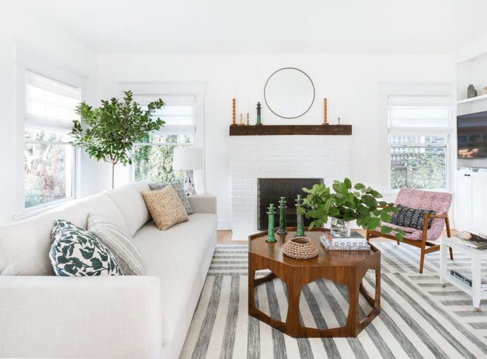A white living room with a fireplace, showcasing the latest home decor trends for Summer 2019.