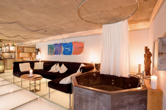 A living room with a couch and a Jacuzzi in the Heinza Julen Loft.