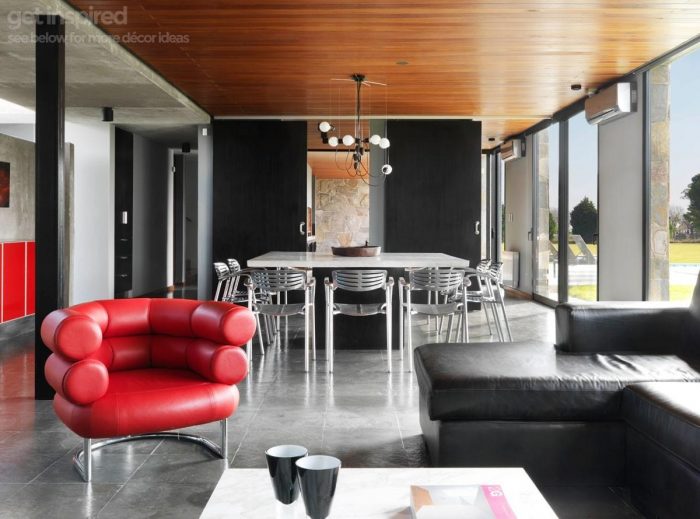 A modern living room with black furniture featuring Eileen Gray Bibendum Chairs.
