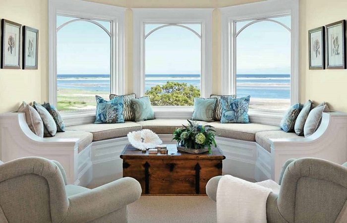 A landed living room with large windows overlooking the ocean.