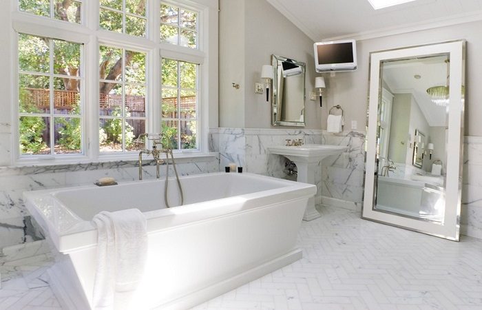 A white bathroom with a mirror.