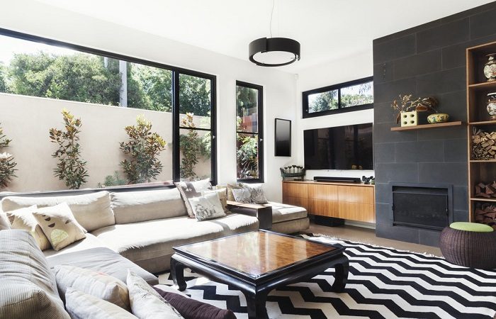 A living room with black and white chevron rugs and furniture.