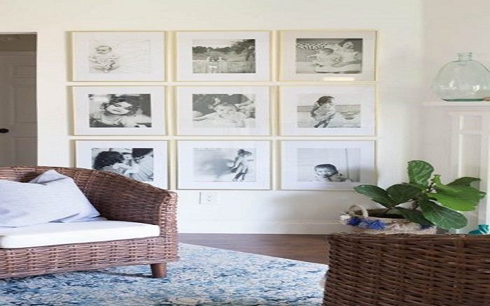 A living room with framed photos and a wicker chair, adding a personal touch.