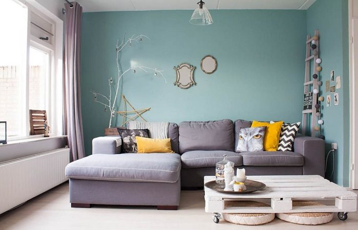 A living room with vibrant blue walls and pops of sunny yellow.