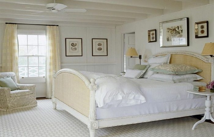 A bedroom with white bed and bedding.