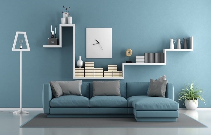A living room with blue walls and shelves, filled with furniture.