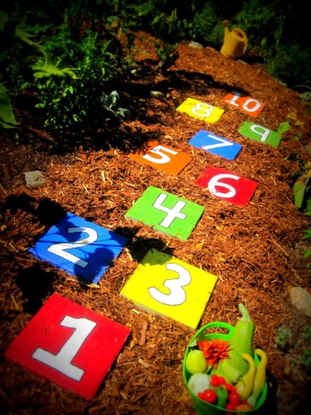 A vibrant and playful playground for kids adorned with colorful numbers in a garden setting.