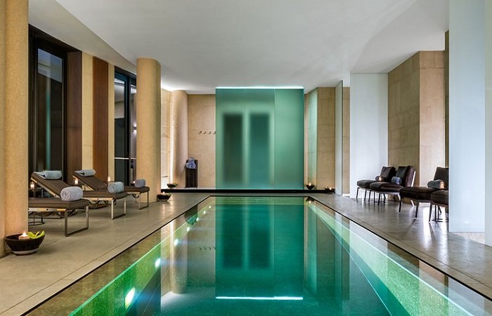 A luxurious spa with a swimming pool in the middle of a room.