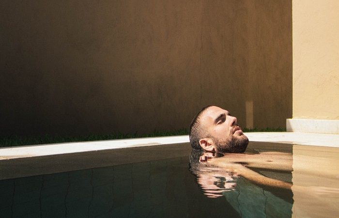 A man enjoying a relaxing spa in a pool.