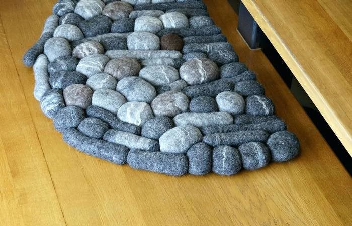 A felt rock rug on a wooden kitchen floor.