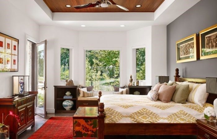 A bedroom with a bed, dresser, and a ceiling fan.