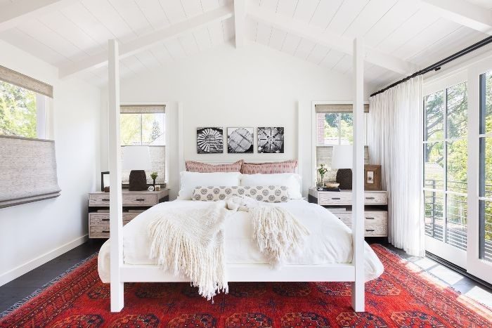 A white bedroom with a four poster bed.
