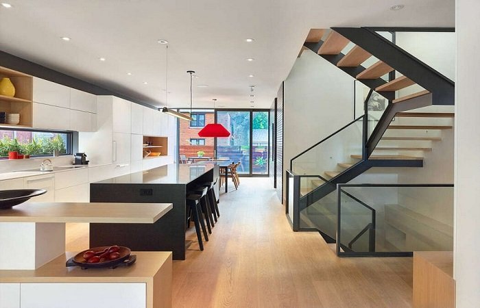 A modern interior with a staircase leading up to the kitchen.